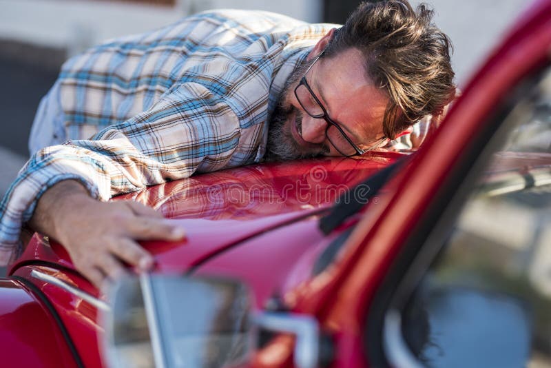 Gut aussehend bärtigen Mann umarmt sein neues Auto und lächelnde Liebe für Auto-Fahrzeug mit erwachsenen reifen Menschen in der Li lizenzfreies stockfoto