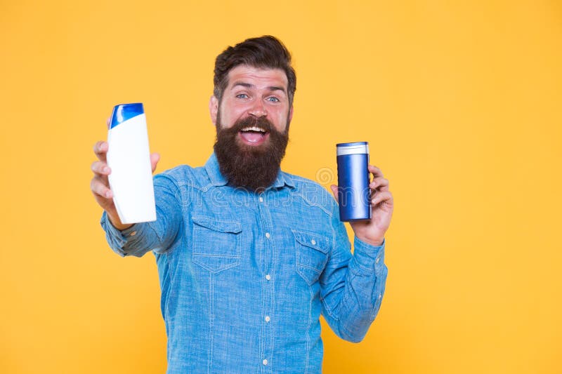 Gute Wahl Happy hipster hold shampoo und konditioner gelber hintergrund Brutale Nesselsucht mit Haarpflegemitteln stockfotos Gute Wahl Happy hipster hold shampoo und konditioner gelber hintergrund Brutale Nesselsucht mit Haarpflegemitteln stockfotos