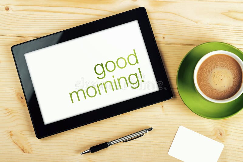 Good Morning Message on Tablet Computer Screen on Office Table. Good Morning Message on Tablet Computer Screen on Office Table.