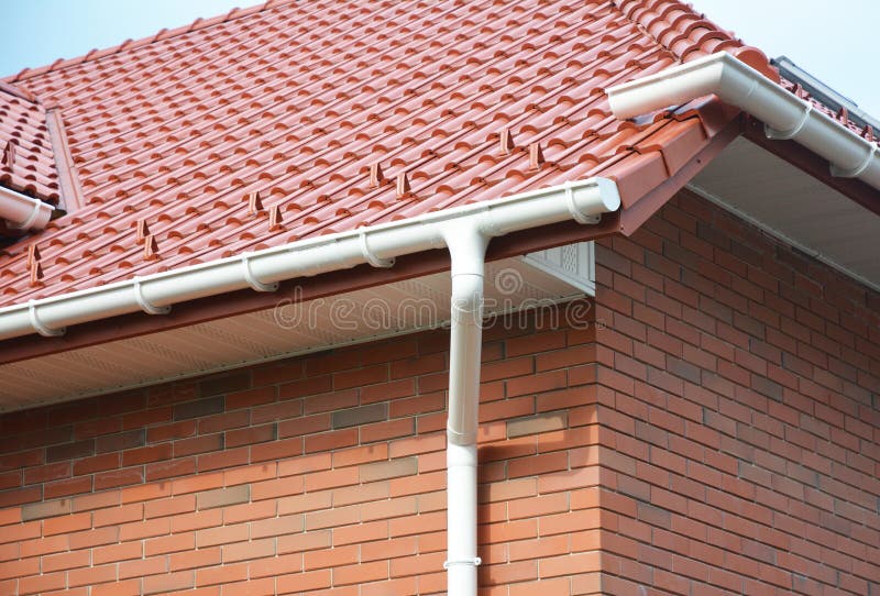 Guttering home, telhando a construção, as calhas, o sistema plástico de Guttering, as telhas de telhado, o Guttering & a construç fotografia de stock Guttering home, telhando a construção, as calhas, o sistema plástico de Guttering, as telhas de telhado, o Guttering & a construç fotografia de stock