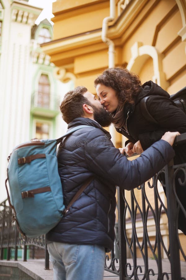 A Guy with a Backpack Kisses a Curly Girl. the Concept of Relationship ...