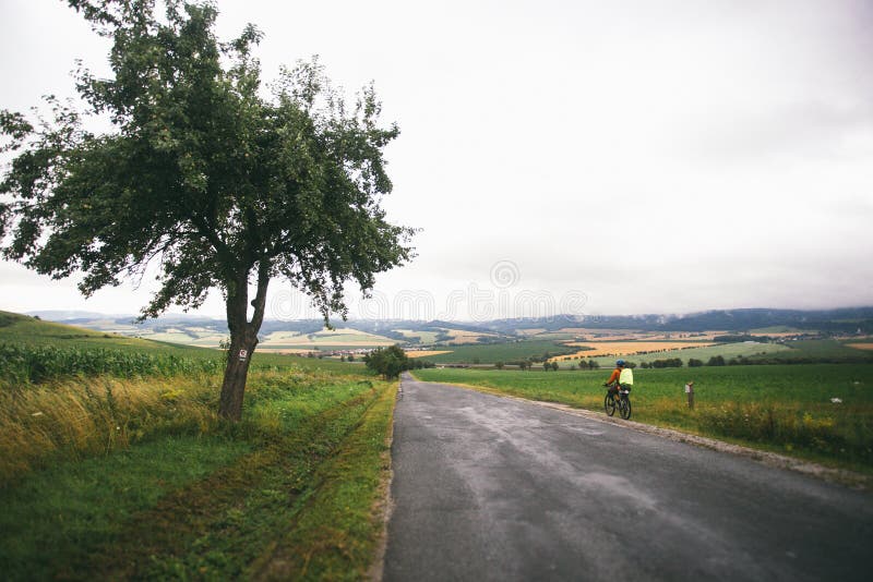 The guy on the Bicycle travels in Slovakia. Blue helmet, green backpack, glasses,