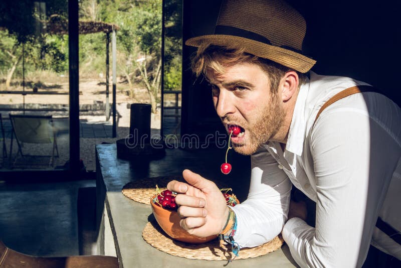 Guy eating cherry fruit stock photo. Image of athlete 121655082