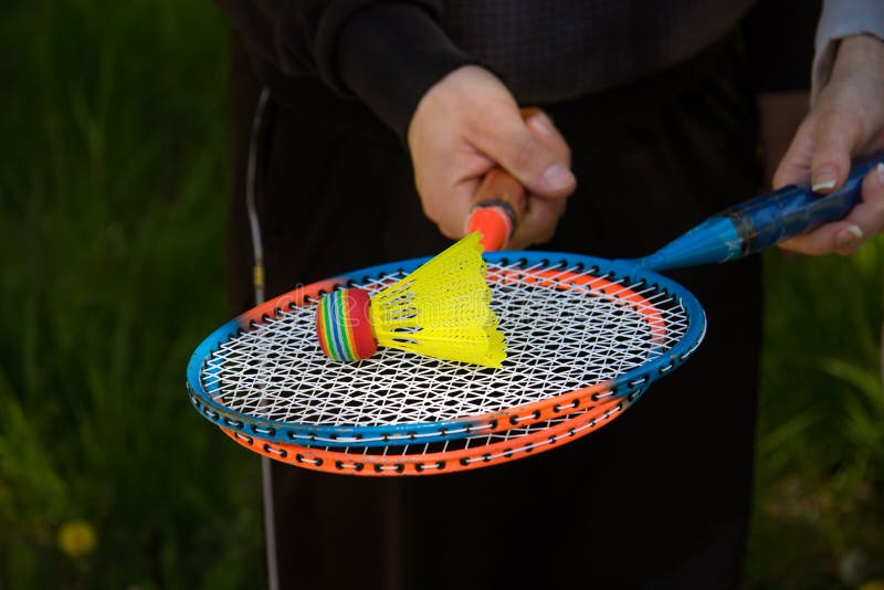 A guy and a girl are holding colorful badminton rackets. On the rackets there is a bright multi-colored flan stock images A guy and a girl are holding colorful badminton rackets. On the rackets there is a bright multi-colored flan stock images