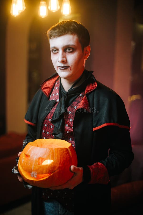 Guy in a Halloween Costume of Count Dracula Holds a Carved Pumpkin in ...