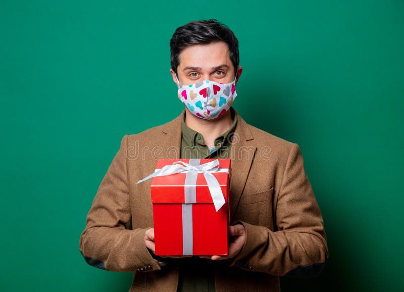 Guy in jacket and face mask hold gift box royalty free stock photos