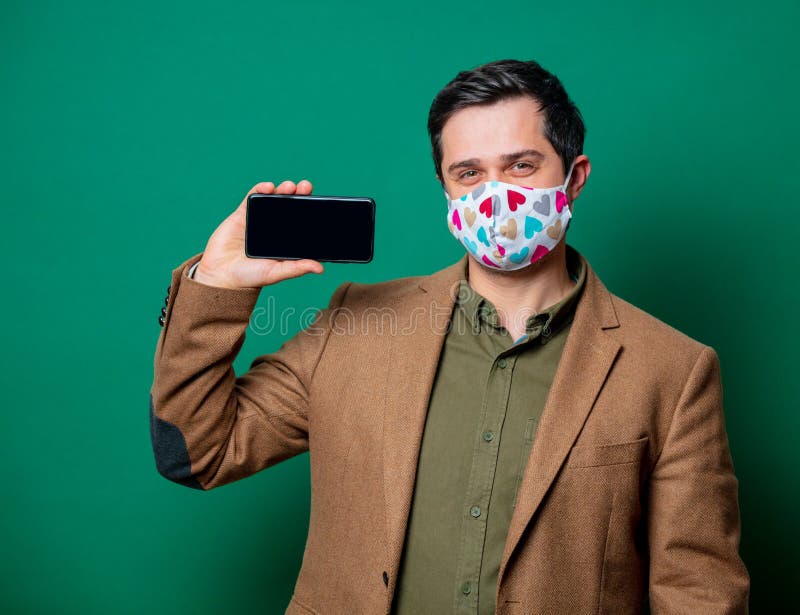 Guy in jacket and face mask hold mobile phone stock photography