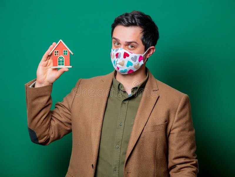Guy in jacket and face mask hold toy house royalty free stock photos