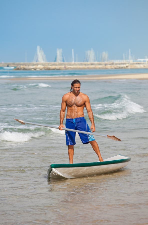 The guy with an oar on a surfboard.