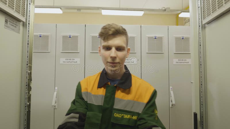 Guy Opens Computer Cabinet in der chemischen Fabrik