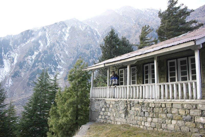 Guy standing on terrace of a cottage in mountain stock photography Guy standing on terrace of a cottage in mountain stock photography