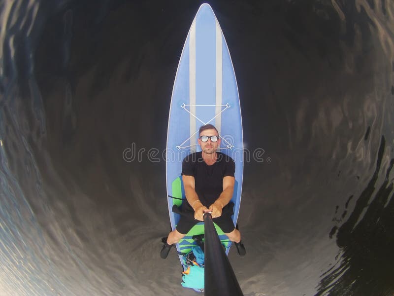Guy in sunglasses lying on puddle boarding top view, SUP serf, stock photography Guy in sunglasses lying on puddle boarding top view, SUP serf, stock photography
