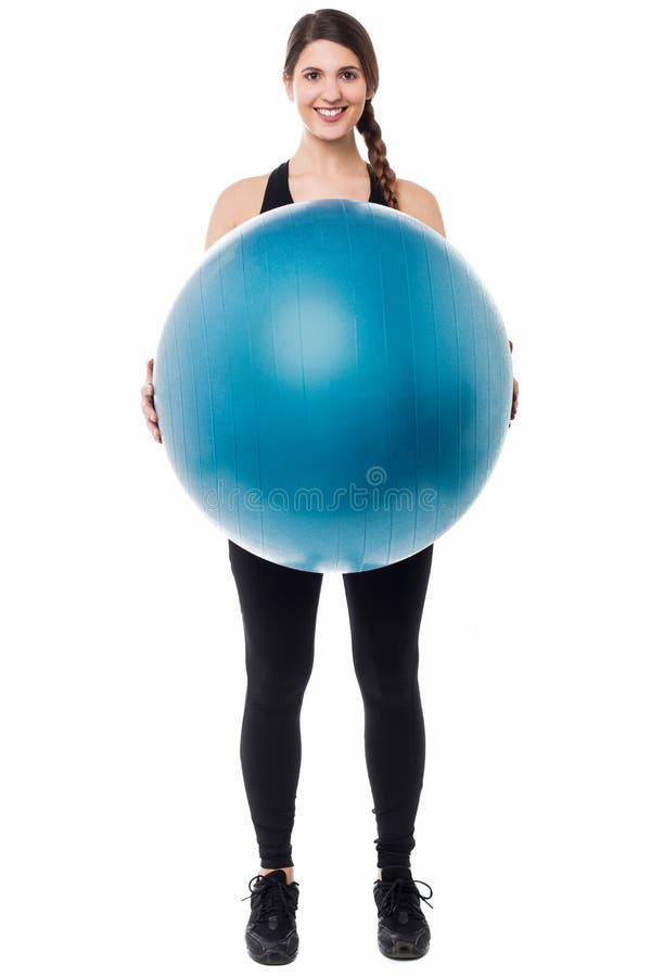 Active female gym instructor displaying a swiss ball. Active female gym instructor displaying a swiss ball.