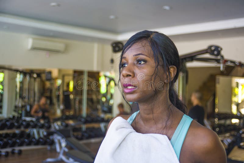 Attractive and tired black afro American woman training at fitness club holding towel drying sweat exhausted and sweaty in treadm stock photo Attractive and tired black afro American woman training at fitness club holding towel drying sweat exhausted and sweaty in treadm stock photo