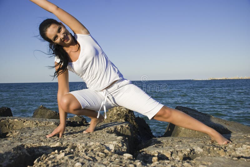 Mujer creación alguno gimnasia sobre el rocas sobre el el mar, fotografías Éste en.