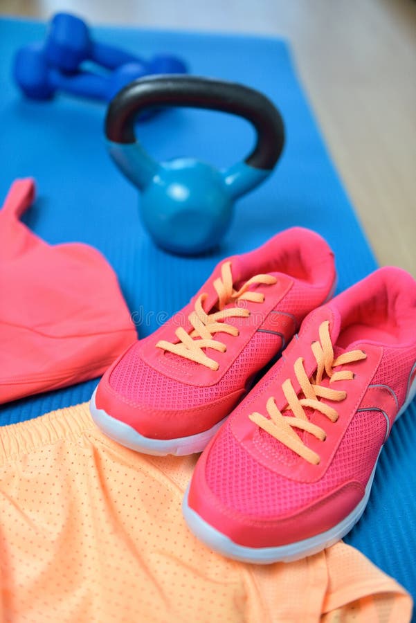 Royalty-Free photo: Close up photo of pink and black kettlebell and running  shoes