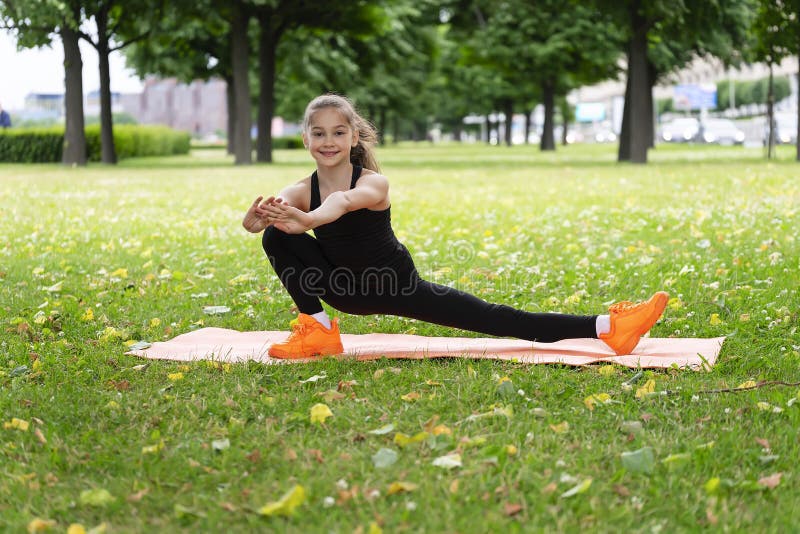 Gymnast Schoolgirl Warming Up in a Grass Park before Performing Complex ...