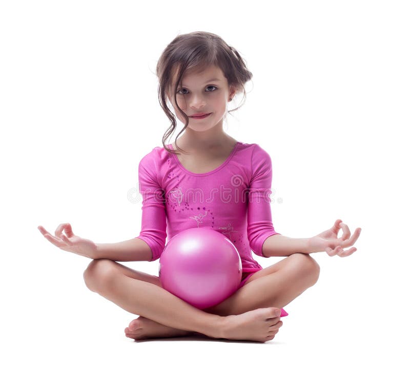 Gymnaste de sourire posant en position de lotus avec la boule