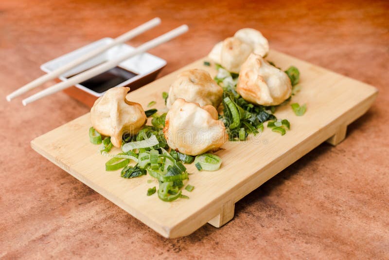Gyoza με τη σάλτσα σόγιας σε έναν ξύλινο πίνακα στοκ φωτογραφία με δικαίωμα ελεύθερης χρήσης Gyoza με τη σάλτσα σόγιας σε έναν ξύλινο πίνακα στοκ φωτογραφία με δικαίωμα ελεύθερης χρήσης