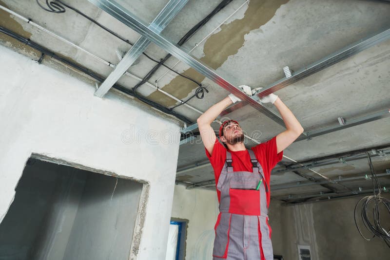 Gypsum plasterboard work. Drywall construction at home. Contractor worker installing metal frame on ceiling