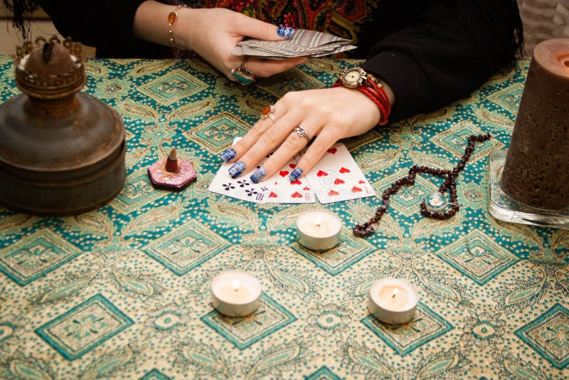 Gypsy fortune-teller laid out the cards on the table next to candles, bahur and other magical paraphernalia, woman, tarot, female, witch, future, mysterious, paranormal, blank, predict, psychic, oracle, divination, mystic, revulsion, background, wizard, fortuneteller, destiny, fate, foresight, astrology, genie, adult, charmer, fantasy, fingers, forecast, foretell, hands. Gypsy fortune-teller laid out the cards on the table next to candles, bahur and other magical paraphernalia, woman, tarot, female, witch, future, mysterious, paranormal, blank, predict, psychic, oracle, divination, mystic, revulsion, background, wizard, fortuneteller, destiny, fate, foresight, astrology, genie, adult, charmer, fantasy, fingers, forecast, foretell, hands