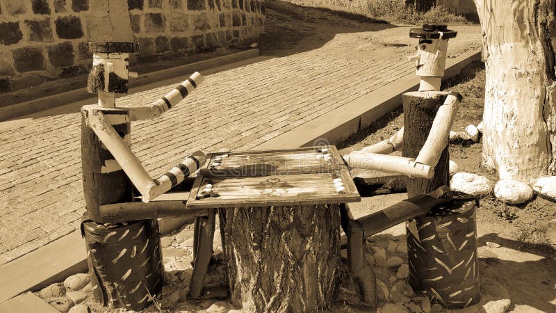 Gyumri, Shirak region / Armenia-September 1, 2020. two people from a tree are playing backgammon. Wooden doll. Table games. The