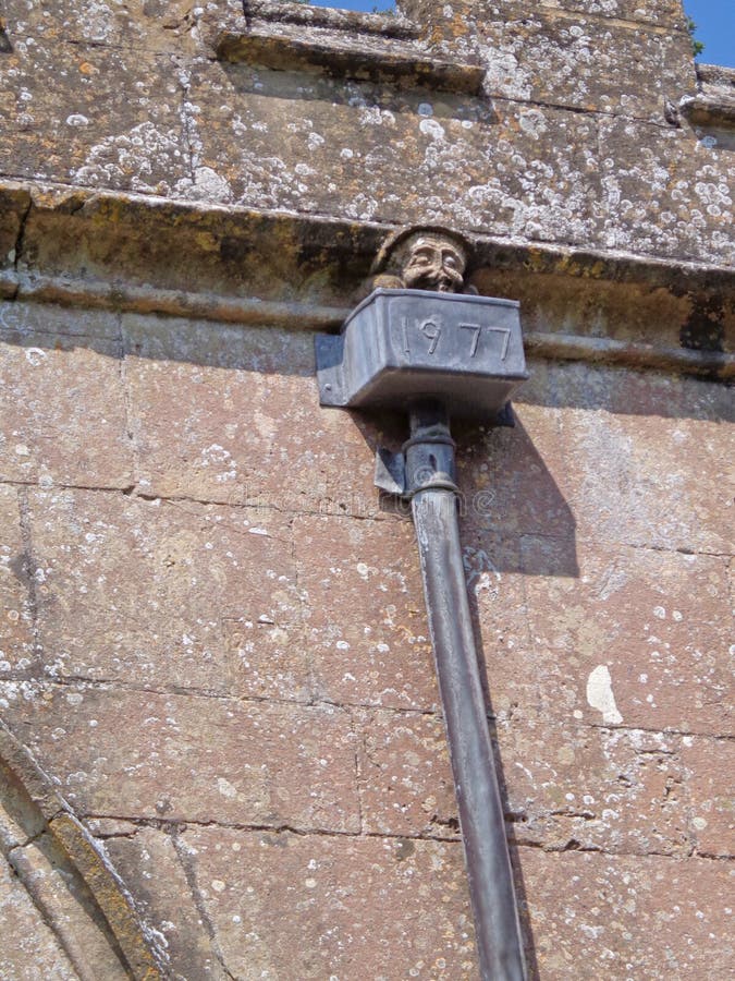 Gárgula inglesa no dreno na igreja velha rural da vila, quase uma ruína fotografia de stock Gárgula inglesa no dreno na igreja velha rural da vila, quase uma ruína fotografia de stock