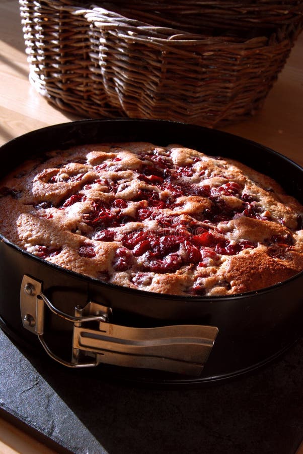 Gâteau de cerise dans un bidon de traitement au four images stock Gâteau de cerise dans un bidon de traitement au four images stock