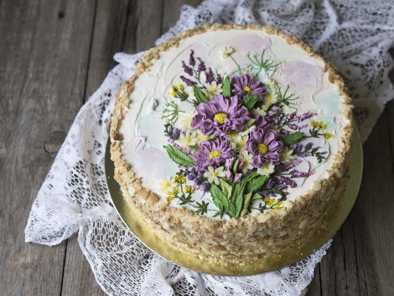 Gâteau de napoléon avec de la crème de vanille, décorée des fleurs de buttercream Type de cru Fond en bois, serviette de dentelle photographie stock Gâteau de napoléon avec de la crème de vanille, décorée des fleurs de buttercream Type de cru Fond en bois, serviette de dentelle photographie stock