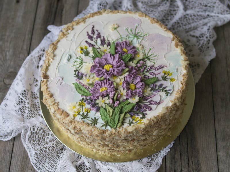 Gâteau de napoléon avec de la crème de vanille, décorée des fleurs de buttercream Type de cru Fond en bois, serviette de dentelle image stock Gâteau de napoléon avec de la crème de vanille, décorée des fleurs de buttercream Type de cru Fond en bois, serviette de dentelle image stock