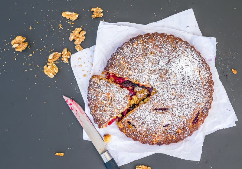 Download Gâteau De Prune Avec Des Noix Sur Un Morceau De Livre Blanc Sur Le Noir Photo stock - Image du poudre, gâteau: 45360664