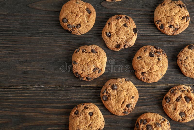 Gâteaux aux pépites de chocolat délicieux sur le fond en bois, configuration plate image libre de droits Gâteaux aux pépites de chocolat délicieux sur le fond en bois, configuration plate image libre de droits