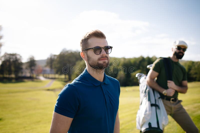 Gå och bärande påse för golfspelare på kurs under sommargam arkivfoto Gå och bärande påse för golfspelare på kurs under sommargam arkivfoto