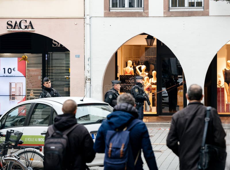 Gångare framme av poliser i Strasbourg efter atta arkivfoto Gångare framme av poliser i Strasbourg efter atta arkivfoto