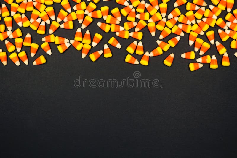 Halloween candy corn top border. Top view on a black background with copy space. Halloween candy corn top border. Top view on a black background with copy space