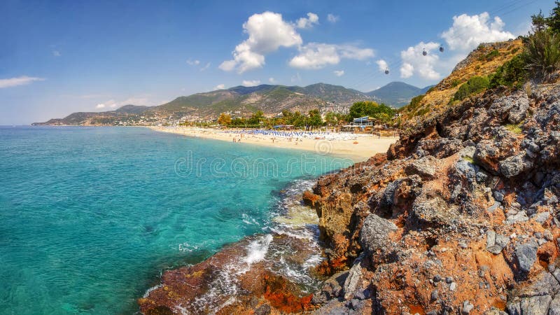 Góry i seascape na pogodnym letnim dniu w Alanya Turcja Piękny widok na tropikalnej plaży i linii brzegowej przez Tureckich skał obrazy stock Góry i seascape na pogodnym letnim dniu w Alanya Turcja Piękny widok na tropikalnej plaży i linii brzegowej przez Tureckich skał obrazy stock