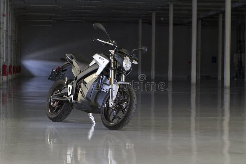 Gör full av hål den elektriska motorcykeln för noll` för ` S i Silverstone hängaren royaltyfri foto Gör full av hål den elektriska motorcykeln för noll` för ` S i Silverstone hängaren royaltyfri foto