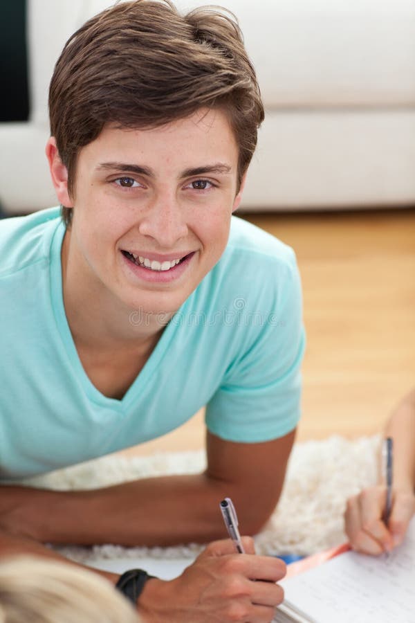 Portrait of a teen guy doing homework on the floor. Portrait of a teen guy doing homework on the floor