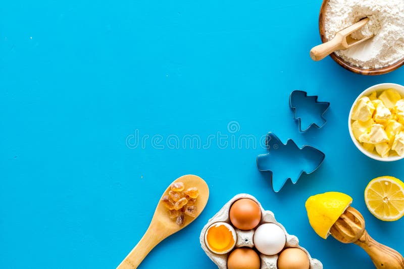 Göra ingredienser på blått bakgrundsyta för text. Ingredienser som mjöl, ägg, smörets överblick