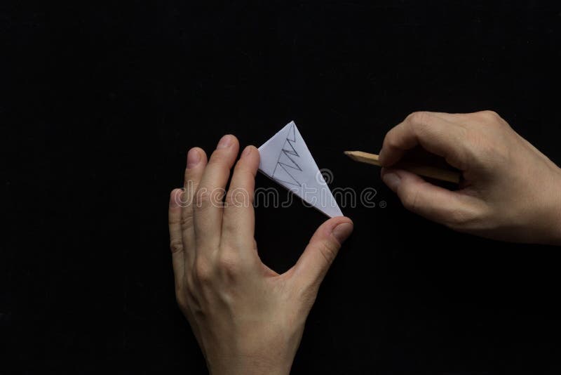 Making snowflake. Step 9. Woman hands drawing lines with pencil to make pattern on future snowflake on black background. Making snowflake. Step 9. Woman hands drawing lines with pencil to make pattern on future snowflake on black background