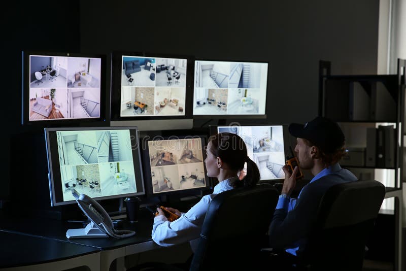 Gărzi de securitate care monitorizează camerele de supraveghere moderne din camera de supraveghere stock images