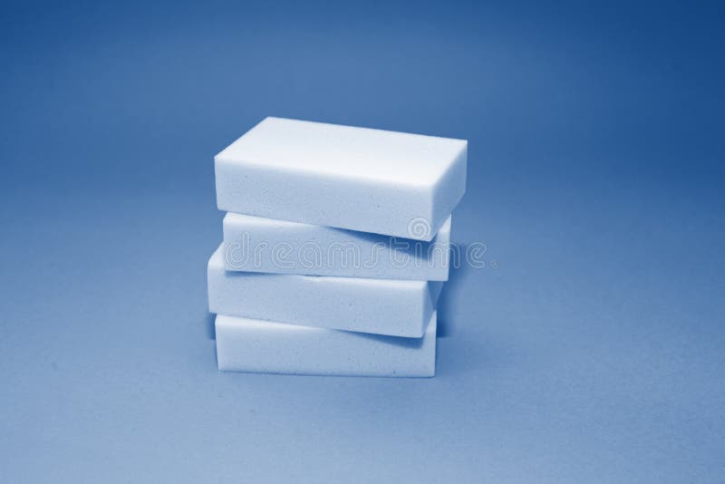 Melamine household sponge. stack with four sponges for cleaning on blue background toned in trendy classic blue color of year 2020. Means for cleaning surfaces from dirt and stains. Cleaning concept. Melamine household sponge. stack with four sponges for cleaning on blue background toned in trendy classic blue color of year 2020. Means for cleaning surfaces from dirt and stains. Cleaning concept