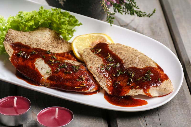 Plaice with red sauce on white plate. Festive and party dish. Plaice with red sauce on white plate. Festive and party dish