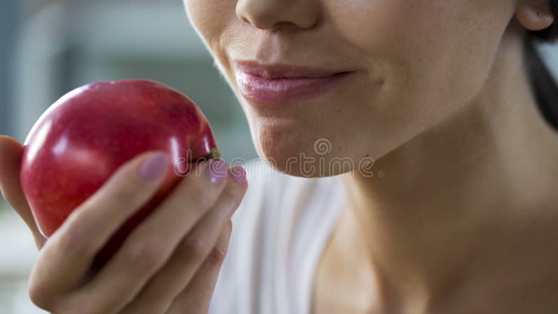Głodna dziewczyna gryźć dużego soczystego jabłka z wielkim apetytem, zdrowa przekąska przy pracą