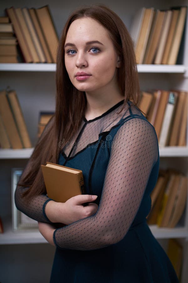 H? bsche Studentin Surrounded durch Bibliotheks-B? cher lizenzfreies stockbild