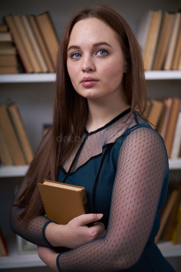 H? bsche Studentin Surrounded durch Bibliotheks-B? cher lizenzfreie stockfotos
