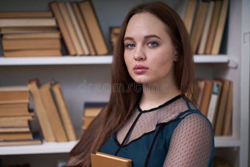 H? bsche Studentin Surrounded durch Bibliotheks-B? cher stockbild
