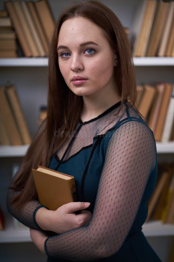 H? bsche Studentin Surrounded durch Bibliotheks-B? cher stockbilder