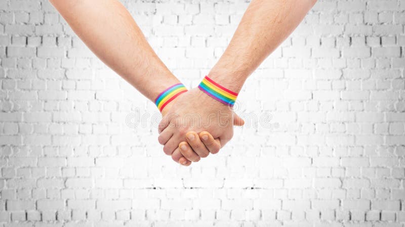 H?nde von Paaren mit Regenbogenmanschetten des homosexuellen Stolzes stockbilder H?nde von Paaren mit Regenbogenmanschetten des homosexuellen Stolzes stockbilder