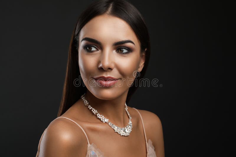 H?rlig ung kvinna med eleganta smycken p? m?rk bakgrund fotografering för bildbyråer H?rlig ung kvinna med eleganta smycken p? m?rk bakgrund fotografering för bildbyråer